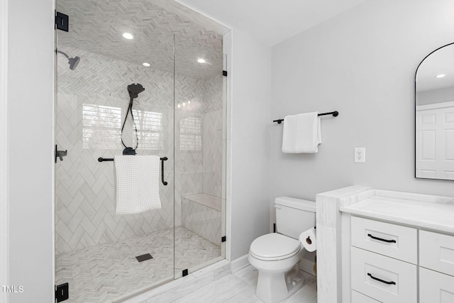 bathroom featuring vanity, toilet, a stall shower, and marble finish floor