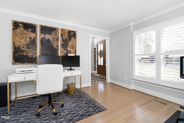 office area with baseboards, wood finished floors, visible vents, and ornamental molding