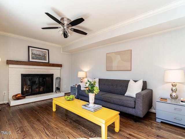 living room featuring ornamental molding, a brick fireplace, a ceiling fan, and wood finished floors