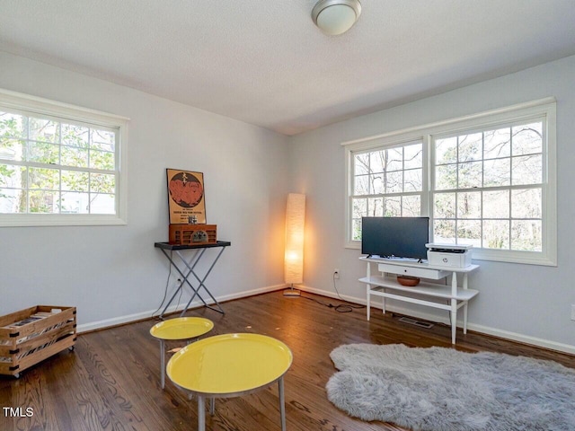 sitting room with a textured ceiling, baseboards, and wood finished floors