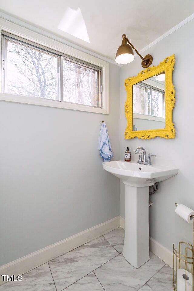 bathroom with a sink, baseboards, and marble finish floor