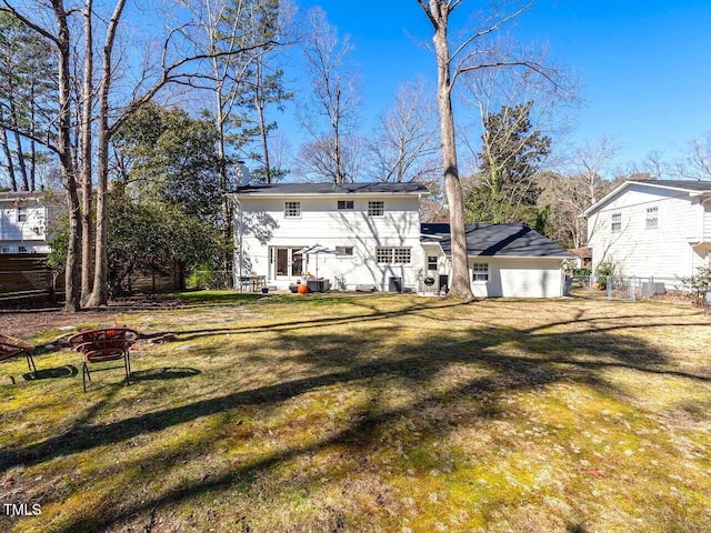 back of house featuring a yard and fence