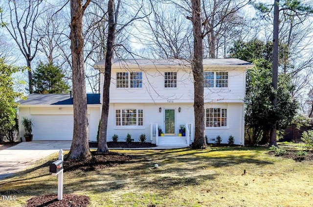 colonial house featuring an attached garage and driveway