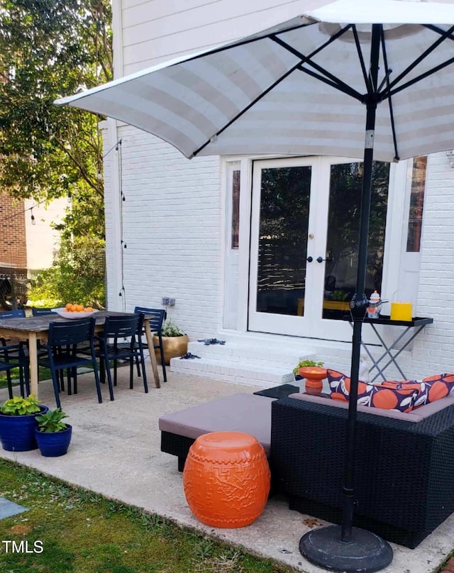 view of patio with outdoor dining space, an outdoor living space, and french doors