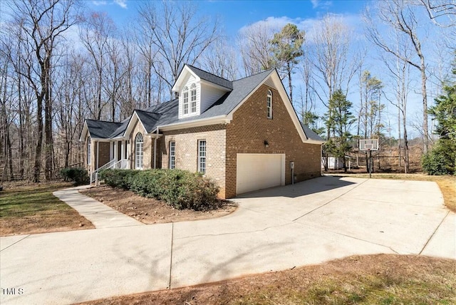 view of property exterior featuring brick siding, concrete driveway, and an attached garage