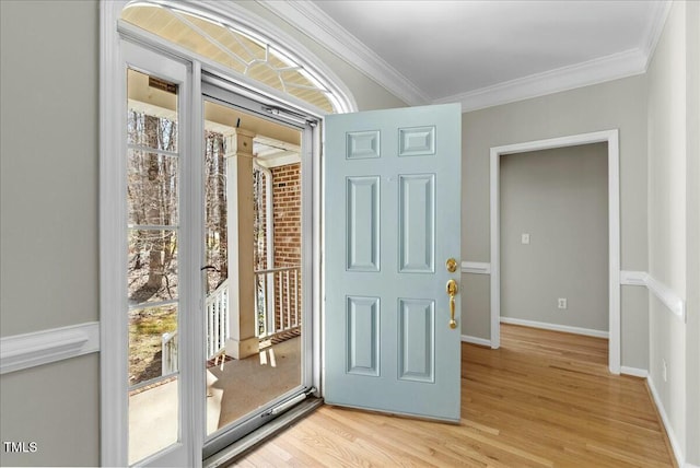 foyer featuring crown molding, light wood-style floors, and baseboards