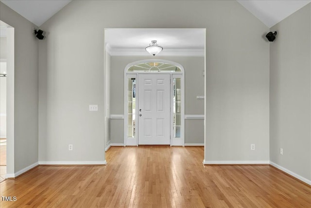 foyer entrance featuring vaulted ceiling, baseboards, and light wood finished floors