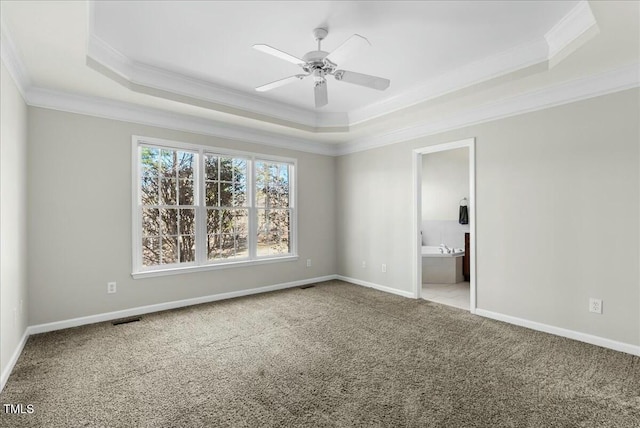 unfurnished bedroom featuring a tray ceiling, visible vents, carpet flooring, and crown molding