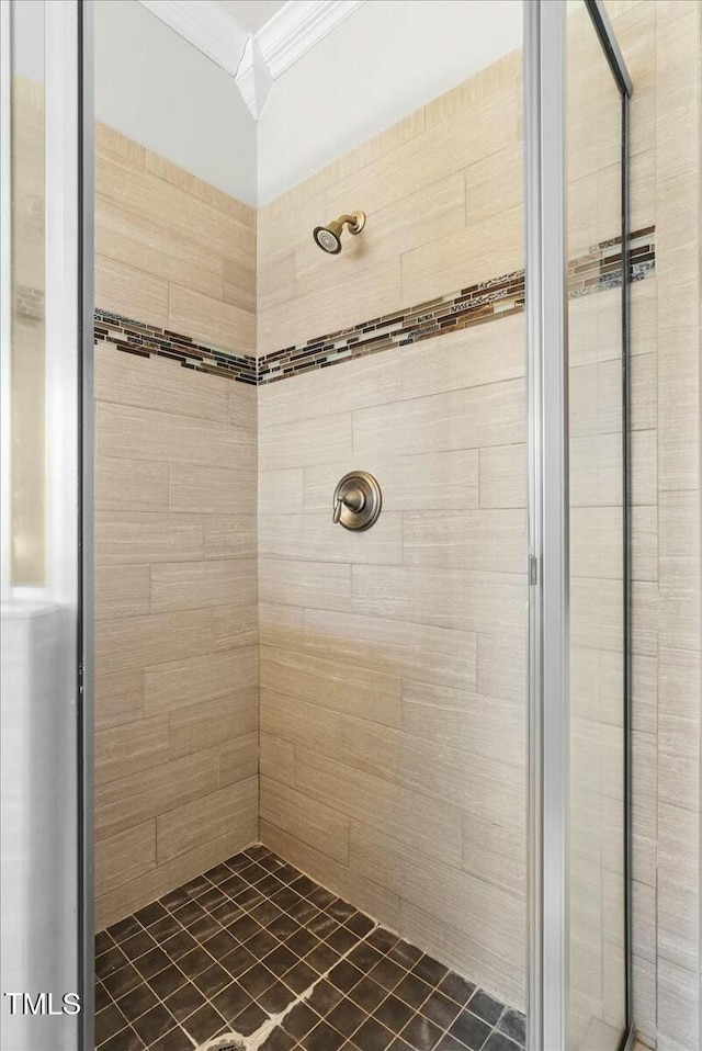 bathroom featuring ornamental molding and a tile shower