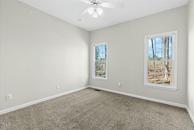 unfurnished room with baseboards, carpet floors, visible vents, and a ceiling fan