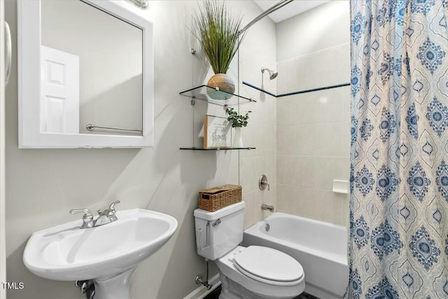 bathroom featuring a sink, shower / bathtub combination with curtain, and toilet