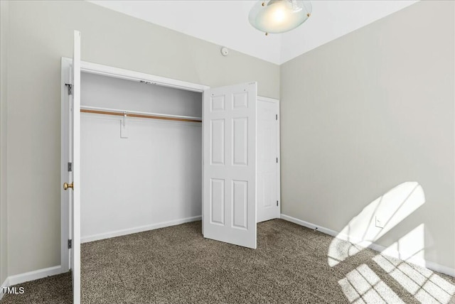 unfurnished bedroom featuring carpet, baseboards, and a closet