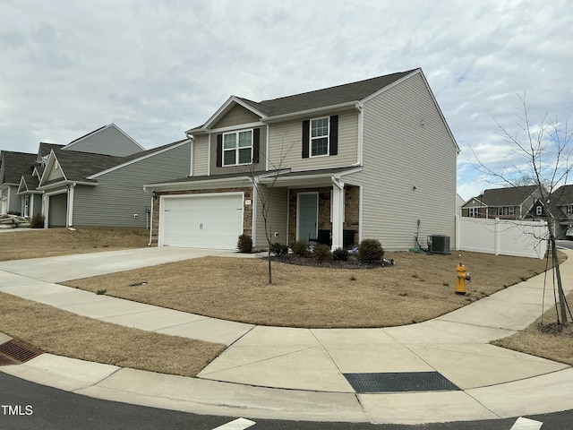 view of front facade with central air condition unit, driveway, a garage, and fence