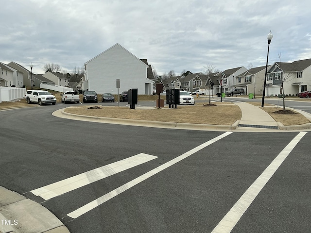 view of street with curbs, a residential view, and street lighting