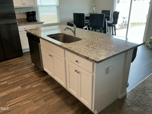 kitchen featuring dishwasher, dark wood finished floors, freestanding refrigerator, and a sink