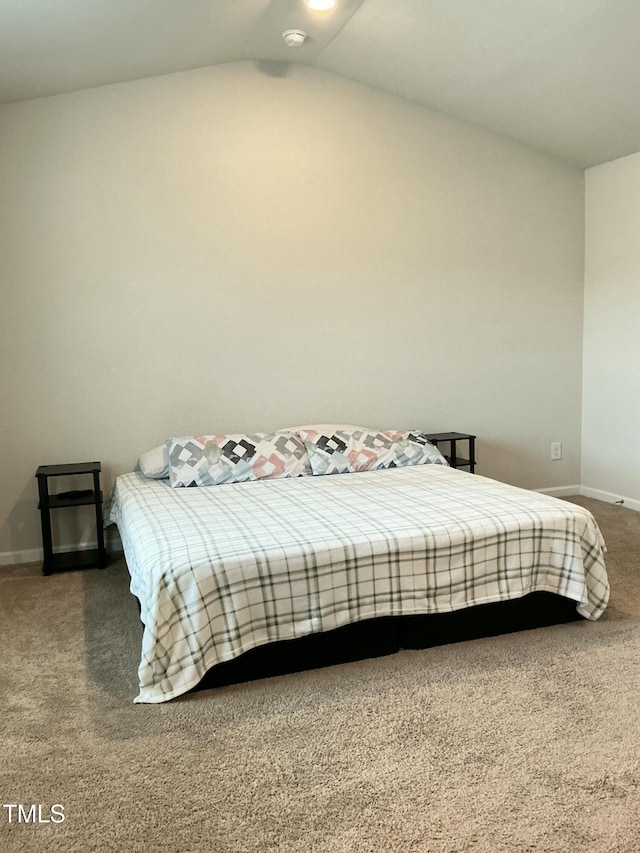 carpeted bedroom featuring vaulted ceiling and baseboards