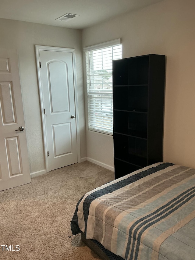 bedroom featuring visible vents, baseboards, and carpet