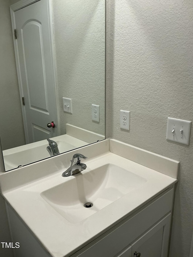 bathroom featuring vanity and a textured wall