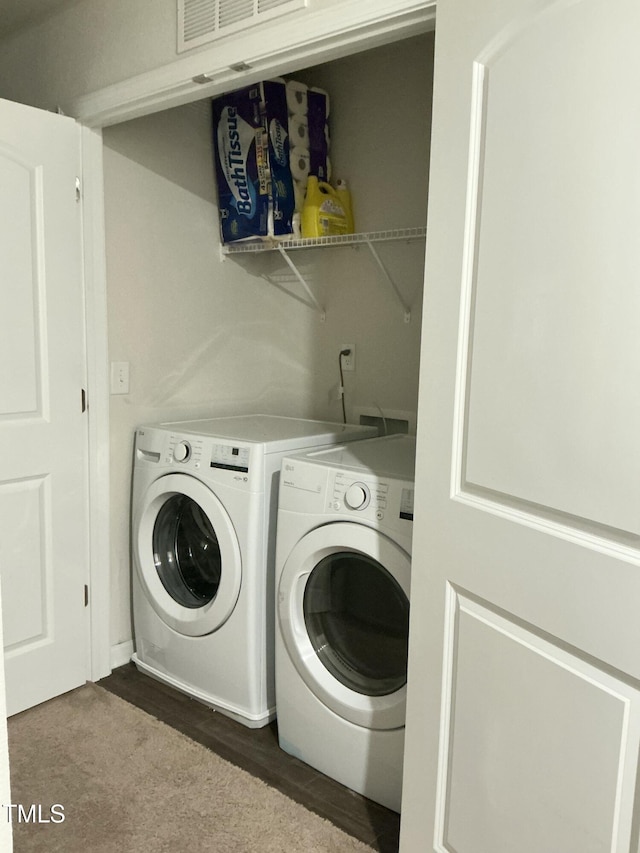 clothes washing area featuring laundry area, independent washer and dryer, and dark wood-style flooring