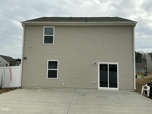 back of property with a patio area and fence