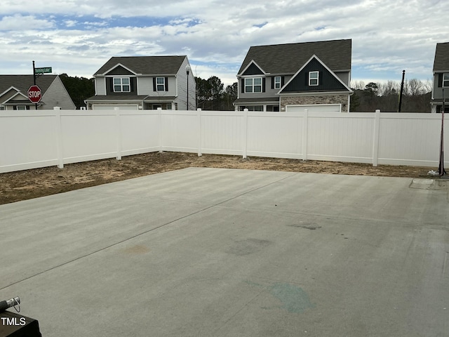 view of patio featuring driveway, an attached garage, and a fenced backyard