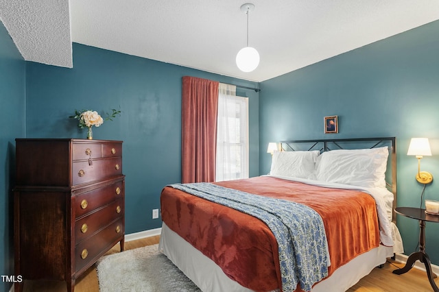 bedroom with wood finished floors and baseboards