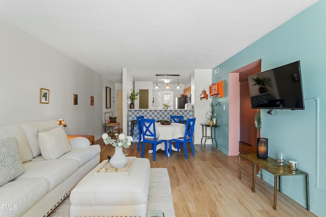 living area with light wood-style floors and baseboards