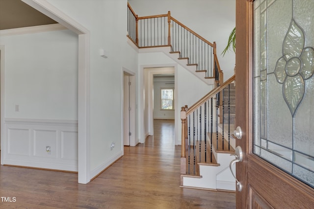 foyer entrance featuring stairway, baseboards, wood finished floors, and ornamental molding