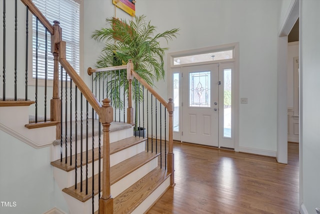 entryway featuring plenty of natural light, stairs, and wood finished floors