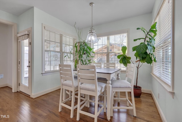 dining room featuring baseboards, a notable chandelier, and wood finished floors