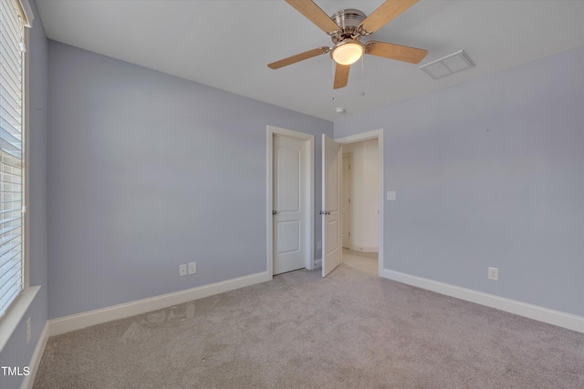 carpeted empty room featuring visible vents, plenty of natural light, and baseboards