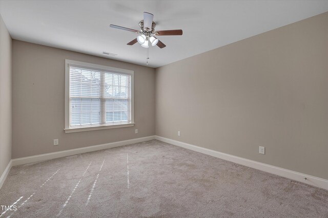 empty room featuring ceiling fan, carpet, visible vents, and baseboards