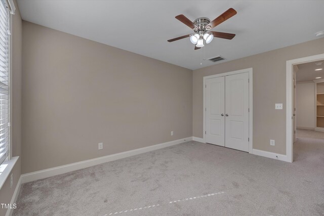 unfurnished bedroom with visible vents, baseboards, carpet, multiple windows, and a closet