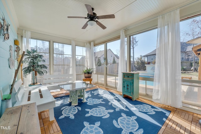 sunroom / solarium featuring a ceiling fan