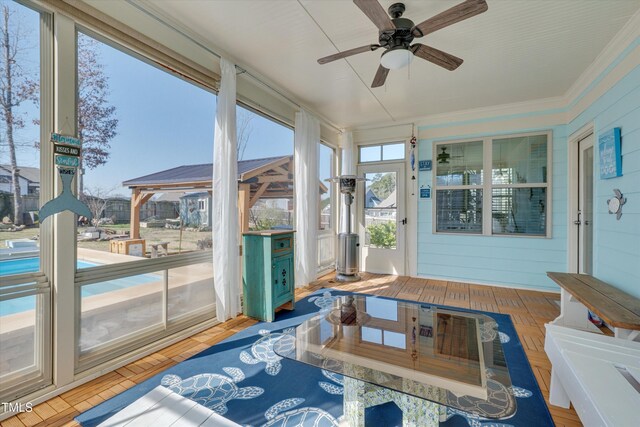 sunroom featuring ceiling fan