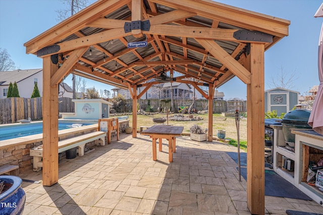 view of patio / terrace featuring a storage shed, a fenced backyard, an outdoor structure, and a grill