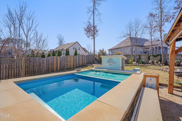 view of pool with a fenced in pool, a patio, an outbuilding, and a fenced backyard