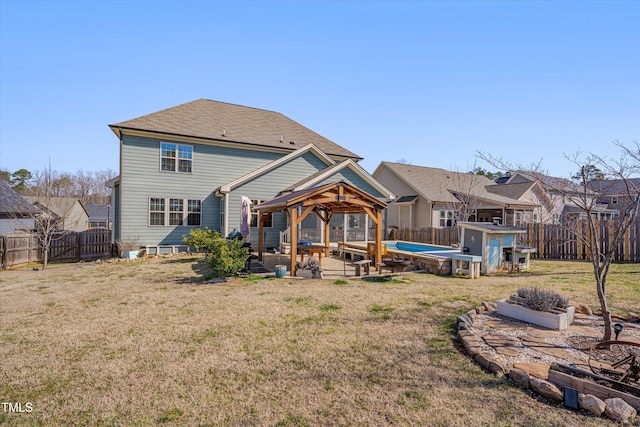 rear view of house featuring a gazebo, a fenced backyard, a patio area, and a yard