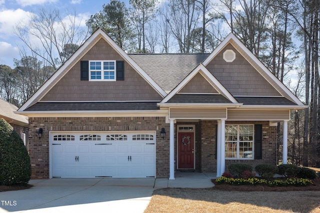 view of front of property featuring brick siding, driveway, an attached garage, and roof with shingles