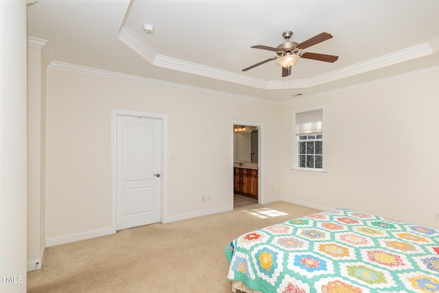 carpeted bedroom featuring a ceiling fan, baseboards, ensuite bath, ornamental molding, and a raised ceiling