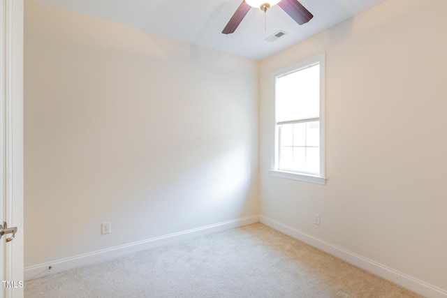 carpeted spare room featuring visible vents, baseboards, and a ceiling fan