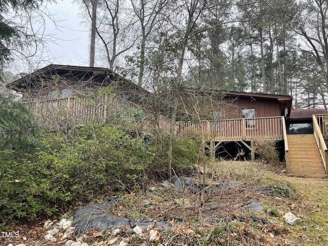 back of property featuring stairway and a wooden deck