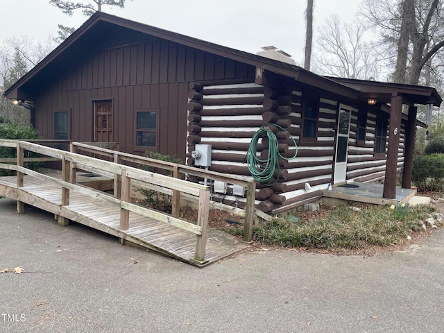 view of property exterior with log exterior and a chimney