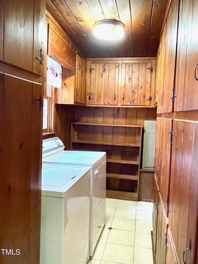 clothes washing area with wood ceiling, light tile patterned floors, cabinet space, and independent washer and dryer