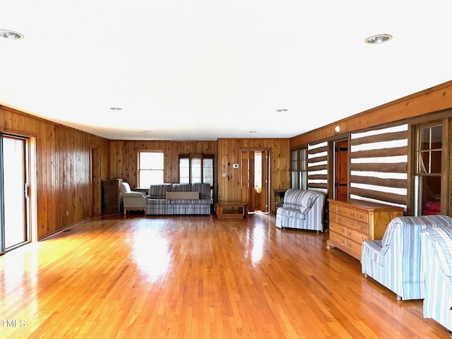 unfurnished living room with wooden walls and light wood-type flooring