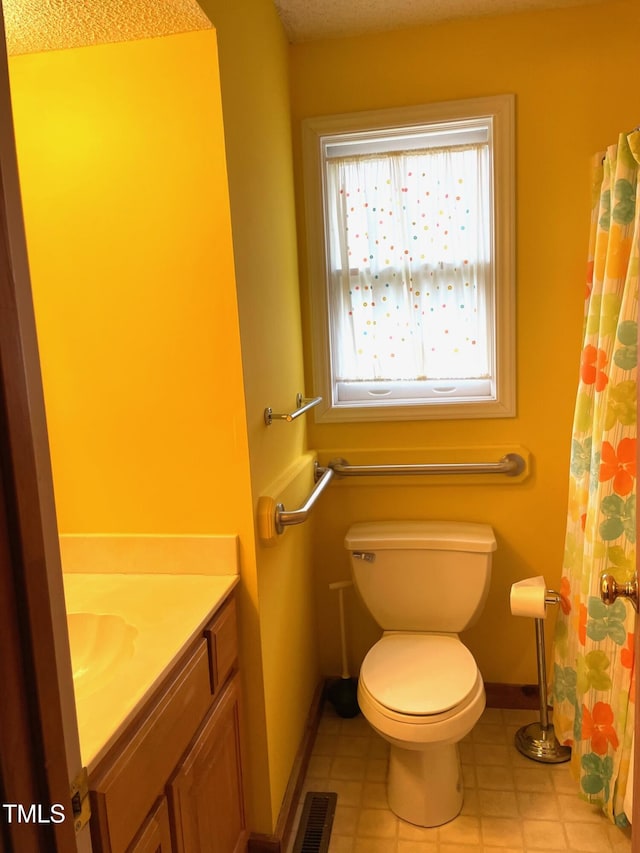 bathroom featuring visible vents, toilet, vanity, and baseboards