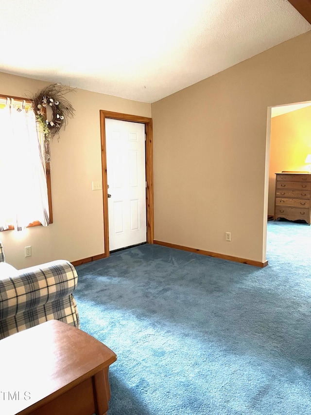 unfurnished living room featuring baseboards and carpet flooring