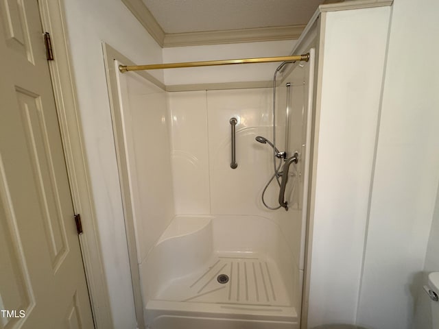 bathroom featuring toilet, ornamental molding, and walk in shower