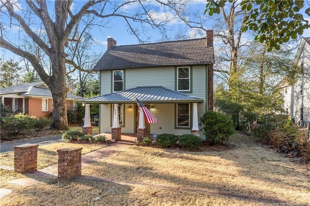 view of front of home featuring a porch and a chimney