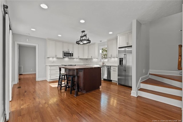 kitchen featuring white cabinets, backsplash, and appliances with stainless steel finishes